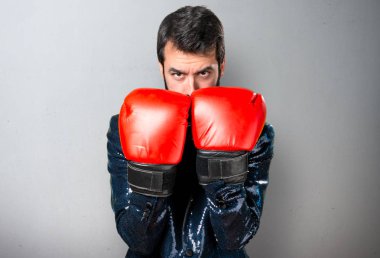 Payet ceket gri arka plan üzerinde boks eldivenli yakışıklı adam