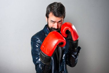 Payet ceket gri arka plan üzerinde boks eldivenli yakışıklı adam