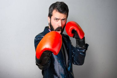 Payet ceket gri arka plan üzerinde boks eldivenli yakışıklı adam