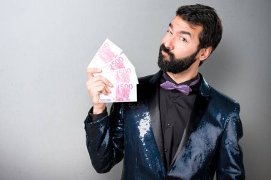 Payet ceket gri arka plan üzerinde bir sürü para alarak yakışıklı adam