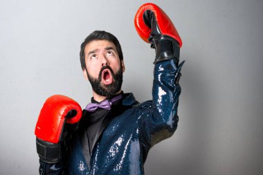 Payet ceket gri arka plan üzerinde boks eldivenli yakışıklı adam