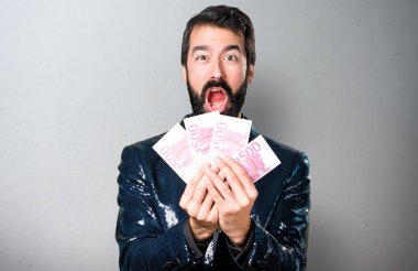 Payet ceket gri arka plan üzerinde bir sürü para alarak yakışıklı adam