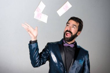 Payet ceket gri arka plan üzerinde bir sürü para alarak yakışıklı adam