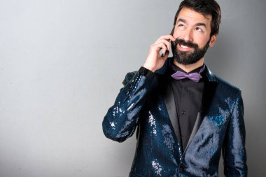 Payet ceket için telefon gri arka plan üzerinde konuşuyor yakışıklı adam