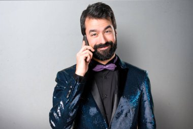 Payet ceket için telefon gri arka plan üzerinde konuşuyor yakışıklı adam