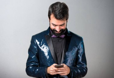 Payet ceket için telefon gri arka plan üzerinde konuşuyor yakışıklı adam