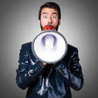 Megafon gri arka plan üzerinde tarafından bağırarak payet ceket ile yakışıklı adam