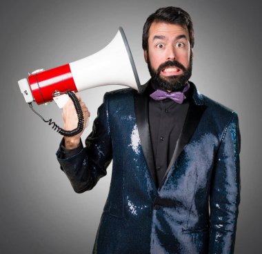 Megafon gri arka plan üzerinde tarafından bağırarak payet ceket ile yakışıklı adam