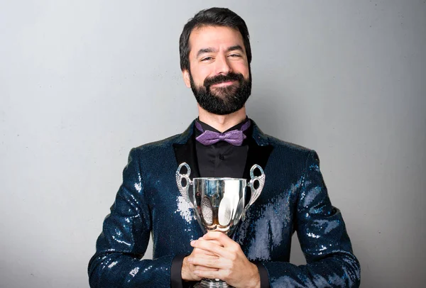 Bir kupa gri arka plan üzerinde tutarak payet ceket ile yakışıklı adam