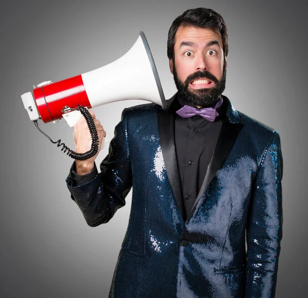 Megafon gri arka plan üzerinde tarafından bağırarak payet ceket ile yakışıklı adam