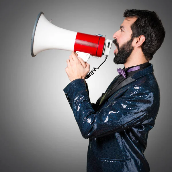 Megafon gri arka plan üzerinde tarafından bağırarak payet ceket ile yakışıklı adam