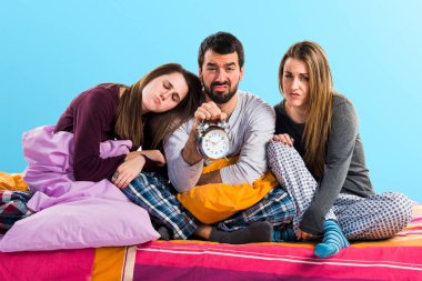 Vintage saat tutan bir yatakta üç arkadaş