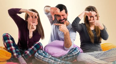 Onun parmaklarıyla odaklanan bir yatakta üç arkadaş