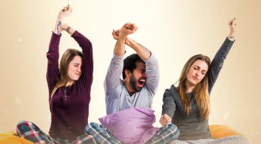 Bir yatak esneme üzerinde üç arkadaş