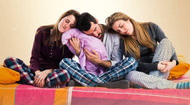 Bir yatakta uyuyan üzerinde üç arkadaş