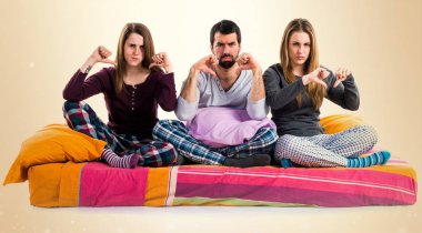 Üç arkadaş bir yatakta kötü sinyal yapıyor