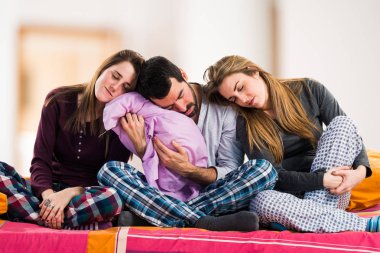 Bir yatakta uyuyan üzerinde üç arkadaş