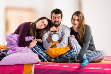 Vintage saat tutan bir yatakta üç arkadaş