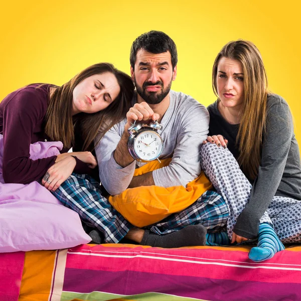 Vintage saat tutan bir yatakta üç arkadaş