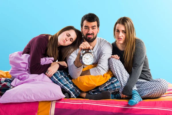 Vintage saat tutan bir yatakta üç arkadaş