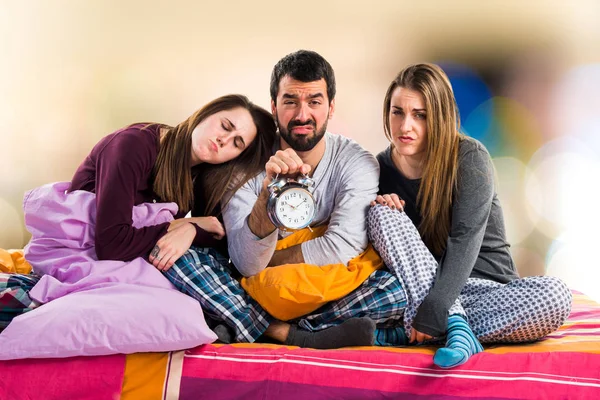 Vintage saat tutan bir yatakta üç arkadaş