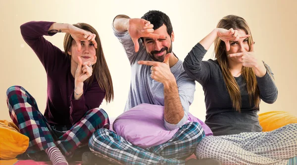 Onun parmaklarıyla odaklanan bir yatakta üç arkadaş