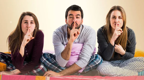 Tres Amigos Una Cama Haciendo Gesto Silencio —  Fotos de Stock