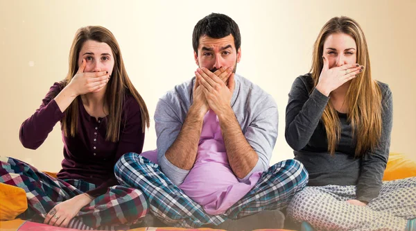 Ağızlarına kapsayan bir yatakta üç arkadaş