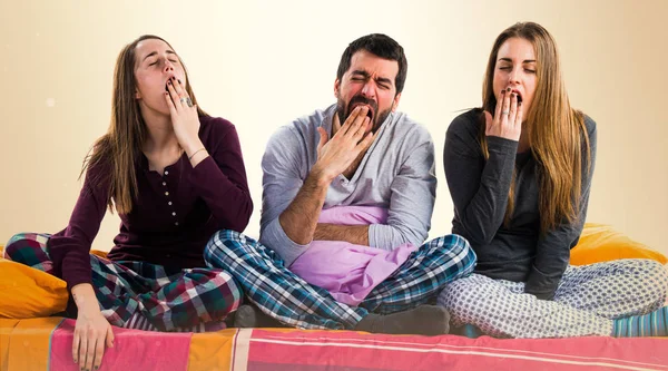 Bir yatak esneme üzerinde üç arkadaş