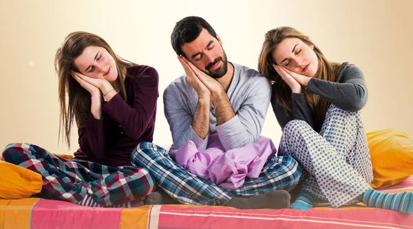 Bir yatakta uyuyan üzerinde üç arkadaş