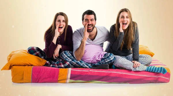 Üç arkadaş bir yatak bağırarak üzerinde