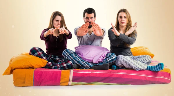 Dur işareti yapmak bir yatakta üç arkadaş