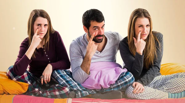 Üç arkadaş bir yatakta bir şeyler gösteriyor