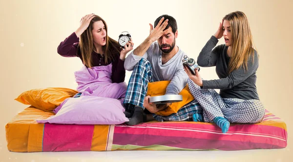 Vintage saat tutan bir yatakta üç arkadaş