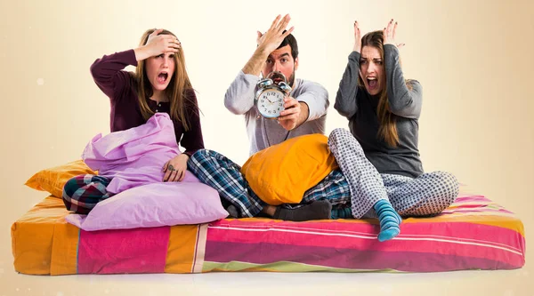 Vintage saat tutan bir yatakta üç arkadaş