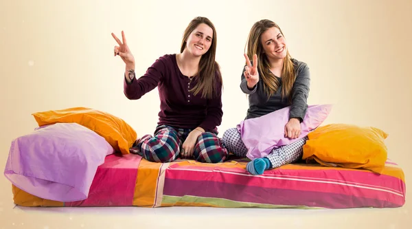 Kız yatakta zafer jest yapıyor