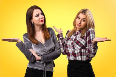 İki arkadaş renkli arka plan üzerinde önemsiz jest yapma