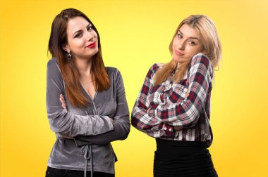 İki arkadaş renkli arka plan üzerinde önemsiz jest yapma