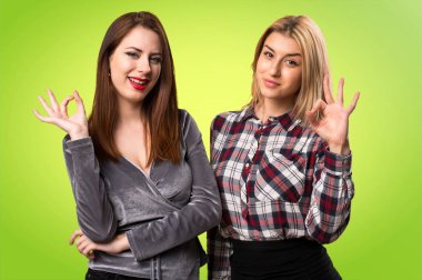 İki arkadaş Tamam renkli arka plan üzerinde kayıt yapma