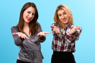 İki arkadaş bir şey renkli arka plan üzerinde sunulması