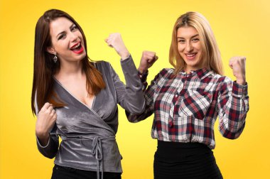 Renkli arka plan üzerinde şanslı iki arkadaş