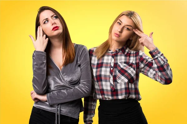 İki arkadaş intihar yapma jest renkli arka plan üzerinde