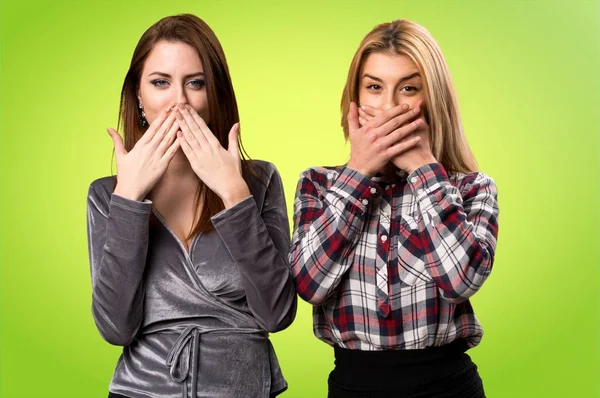 İki arkadaş ağızları renkli arka plan üzerinde kapsayan