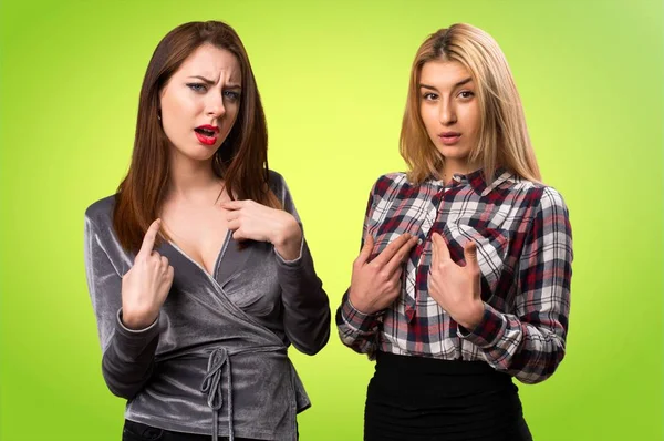 İki arkadaş sürpriz yapma jest renkli arka plan üzerinde