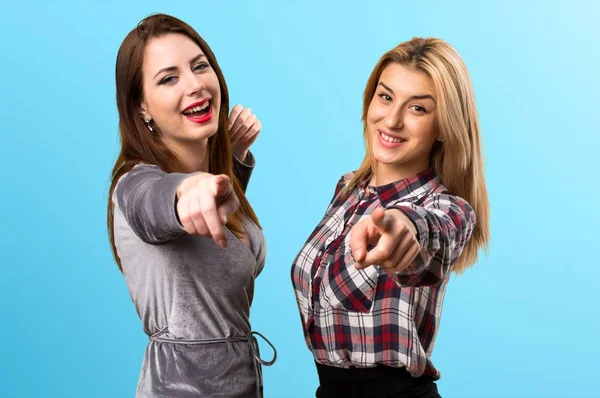 Açık renkli arka plan üzerinde işaret eden iki arkadaş