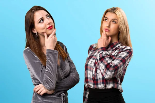 İki arkadaş renkli arka plan üzerinde düşünme