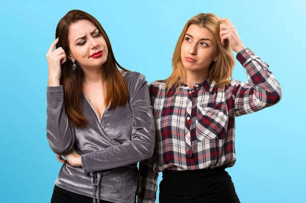 Dos Amigos Que Tienen Dudas Sobre Fondo Colorido — Foto de Stock