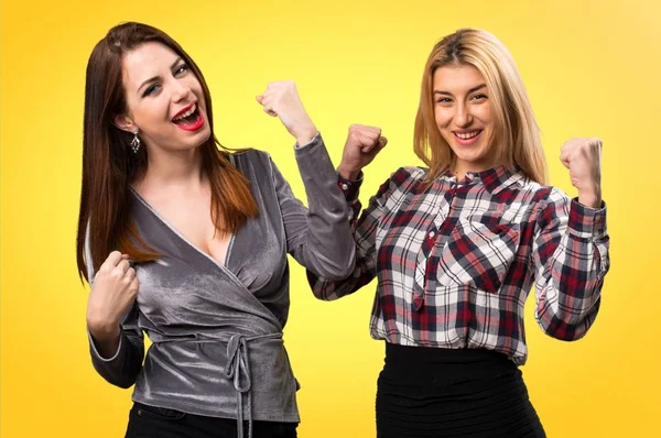 Renkli arka plan üzerinde şanslı iki arkadaş