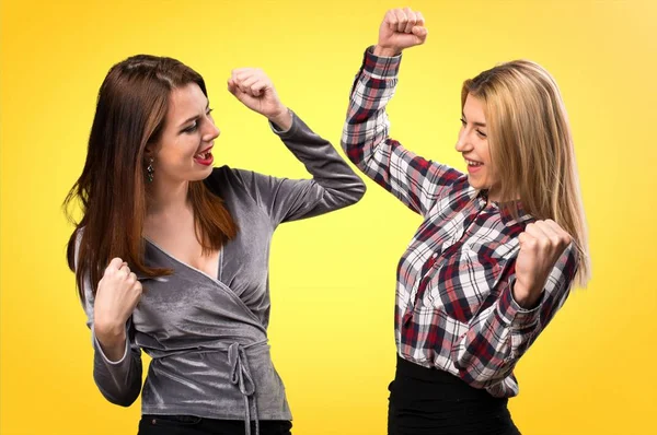 Renkli arka plan üzerinde şanslı iki arkadaş