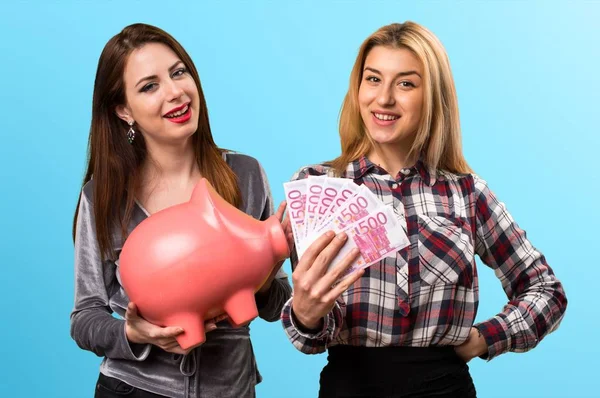 Two Friends Holding Piggybank Lot Money Colorful Background — Stock Photo, Image